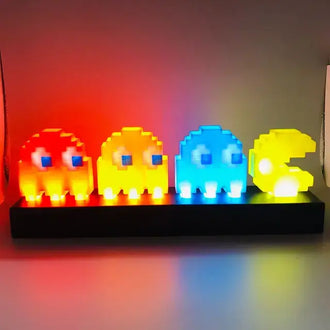 Pac-Man and colorful ghost LED night light in pixel art style, perfect for gaming room decor and nostalgia.